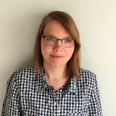 Headshot of Anna Mykailova wearing a black and white checkerboard shirt